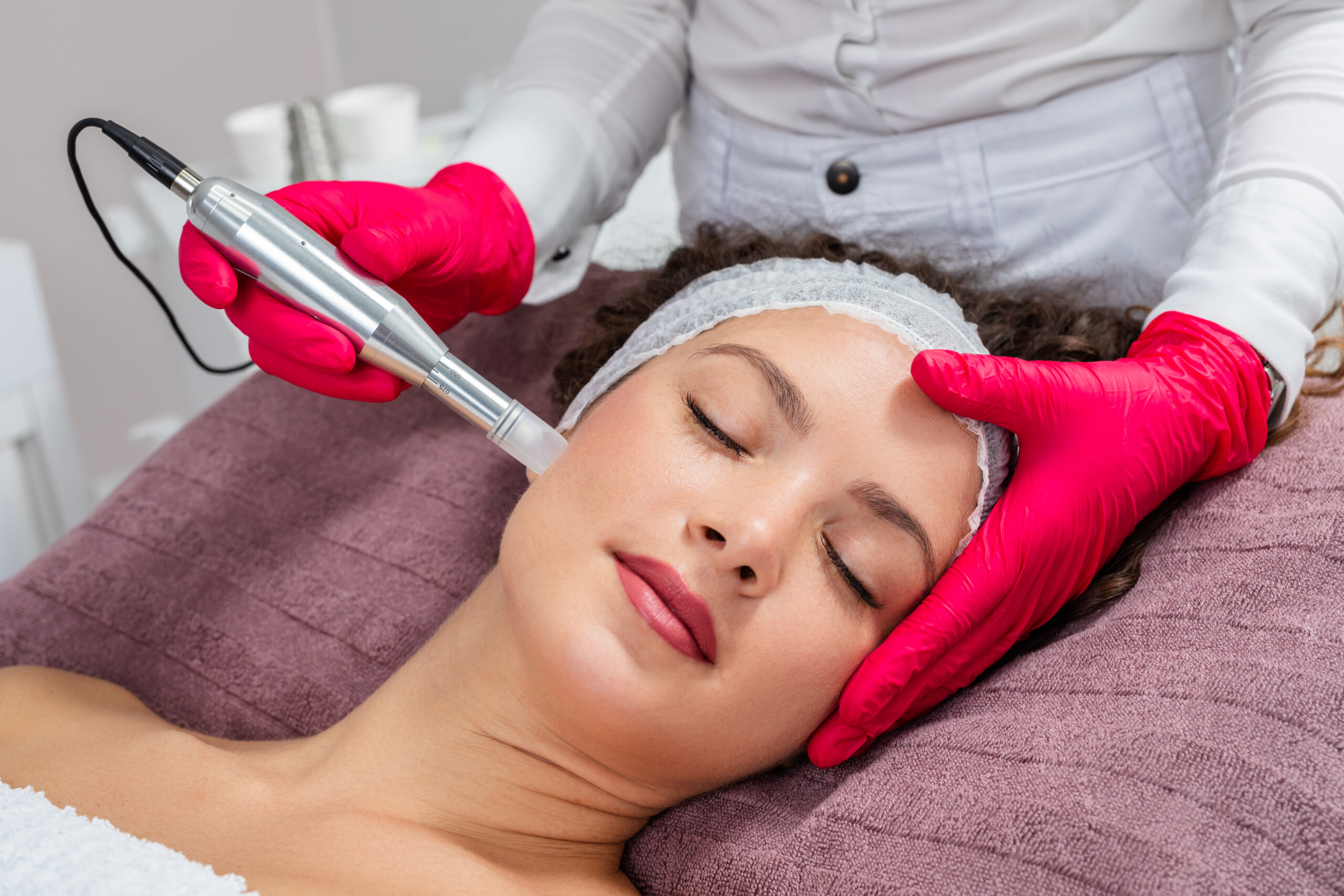 woman receiving microneedling treatment on face